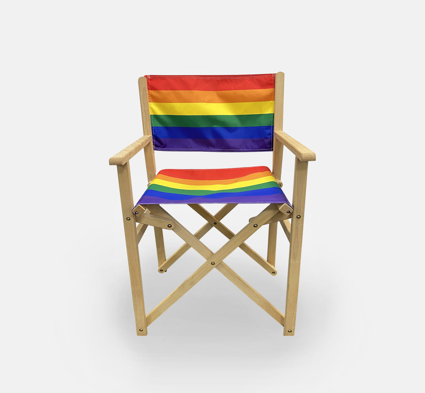 Brown wooden directors chair with a six-colour rainbow flag sling on the back and seat.
